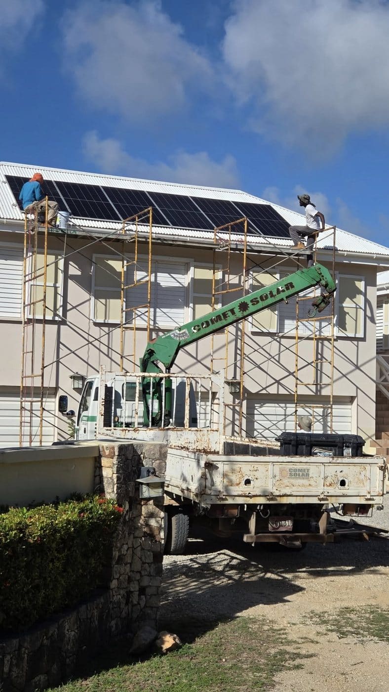 Comet Solar crane truck and crew installing solar panels on a commercial building