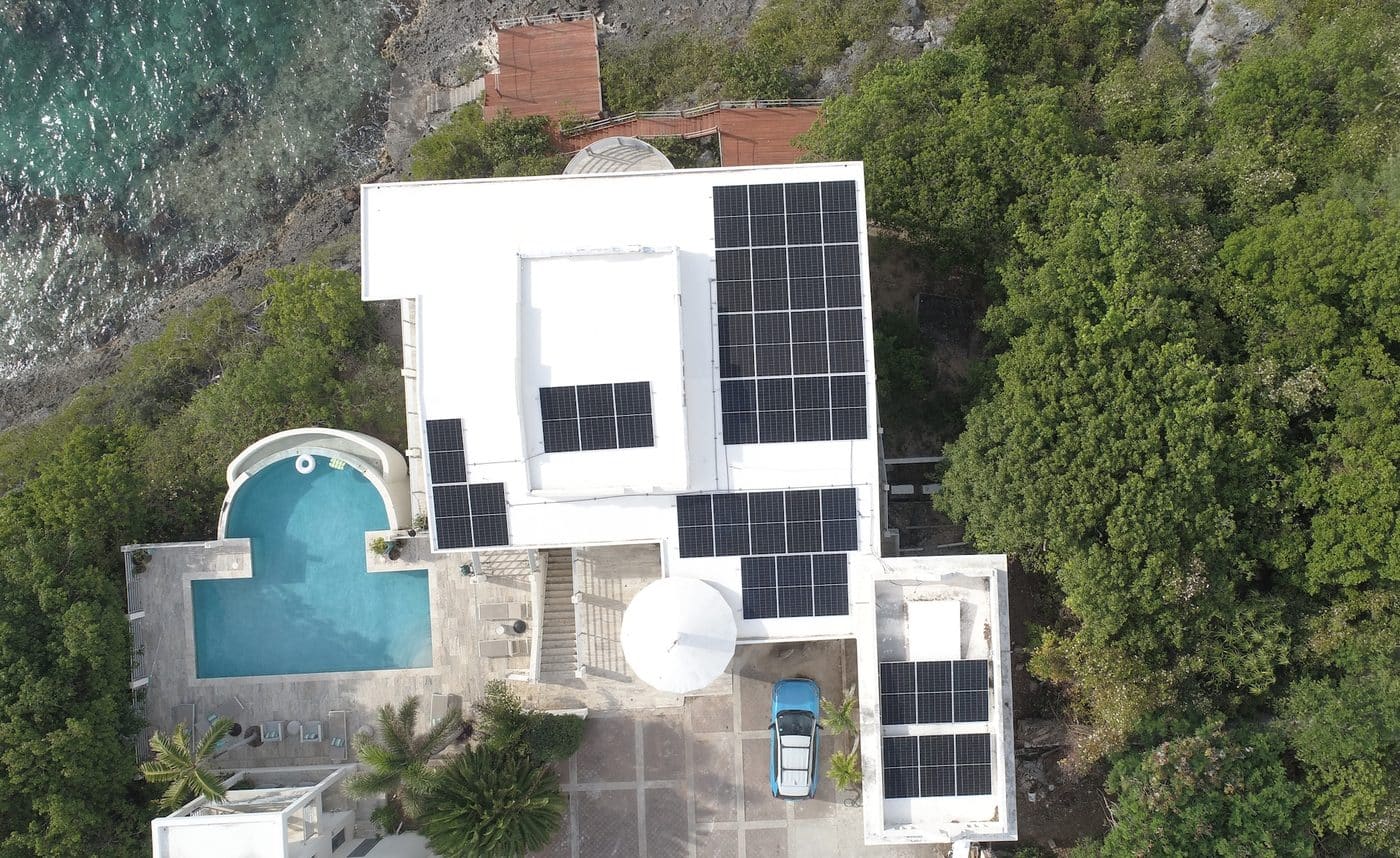Drone top-down view of villa with full roof solar panel coverage