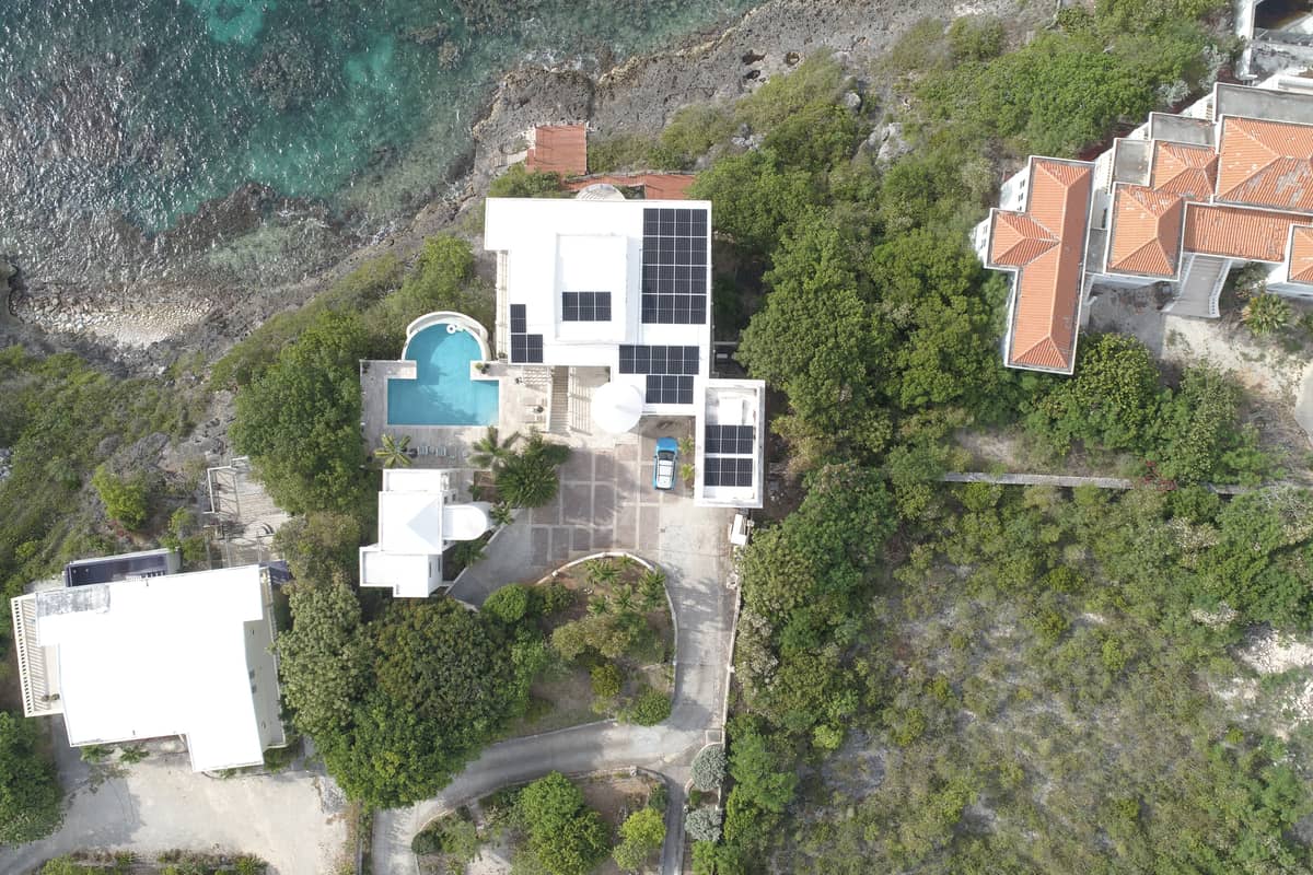 Aerial view of a Caribbean villa with rooftop solar panels